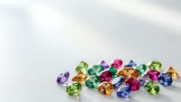 Colorful mixed gemstones collection featuring emerald, sapphire, ruby, topaz and peridot on white background for jewelry design and luxury accessories.