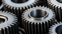 Metal industrial gears and cog wheels in close-up view showing mechanical engineering details, machine parts, and precision manufacturing components.