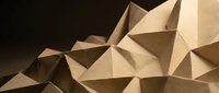 Abstract geometric paper origami sculpture with angular triangular facets creating dimensional shadows and depth on neutral background.