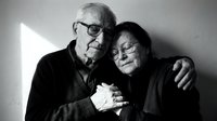 Elderly couple embracing in tender moment, black and white portrait showing love and companionship in golden years of marriage and relationship.