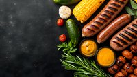 Grilled sausages with fresh vegetables, corn, mushrooms, cucumber and sauces on dark background. Summer barbecue food composition with copy space.