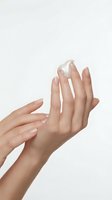 Female hands with light skin tone applying white moisturizing cream or lotion, demonstrating skincare routine and cosmetic product usage for beauty and wellness purposes.