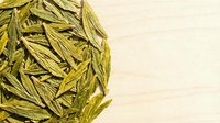 Dried fennel seeds scattered on light wooden surface, ideal for culinary, herbal medicine, and food photography projects.