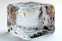 Clear ice cube with natural cracks and air bubbles inside shows crystalline structure on white background, macro photography highlights transparency and texture.