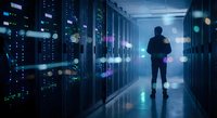 IT professional walking through modern data center server room with glowing blue lights and network equipment for technology and cloud computing concepts.