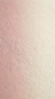 Soft pink gradient textured surface with natural grain pattern fading to cream, organic material background for cosmetic and wellness design projects.