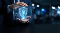 Businessman holding glowing digital shield with padlock icon, representing cybersecurity, data protection, and network security solutions for enterprise business applications.