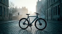 Black fixed-gear bicycle parked on cobblestone street with historic architecture and misty morning light, suitable for urban lifestyle and transportation concepts.