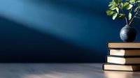 Stack of books with green plant in blue ceramic vase against dark blue wall with dramatic lighting, creating minimalist composition for study, education and home decor concepts.