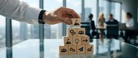 Businessman stacking wooden blocks with business icons in modern office environment, representing strategy, growth, and organizational planning for corporate success.