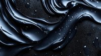 Flowing black liquid waves create dramatic abstract texture with shimmering droplets and glossy ripples against dark background, suitable for luxury product designs.