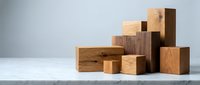 Wooden blocks and cubes in various sizes and natural wood tones arranged in an abstract composition on white surface for design and branding projects.