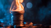 Stack of silver coins with flame burning on top against dark background with blue bokeh lights, representing financial crisis, cryptocurrency volatility or hot investment trends.