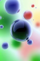 Colorful translucent spheres floating against vibrant green and yellow gradient background, creating abstract molecular or bubble-like composition.