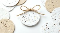 Isolated round cork coasters with speckled texture and natural twine bow on white background, ready for product mockups, packaging design, home decor projects, and e-commerce use.