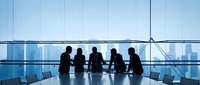 Business professionals silhouettes meeting in modern conference room with city skyline view through large windows for corporate presentations.