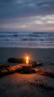 Romantic candle glowing on sandy beach at twilight with driftwood and ocean waves creating peaceful meditation atmosphere for relaxation and mindfulness.
