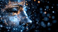 Magical glowing particles and bokeh lights create ethereal swirling patterns against dark background, combining blue and golden colors in cosmic dance-like motion.