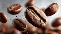Roasted coffee beans falling with motion blur creating dynamic splash effect for cafe branding and beverage marketing materials.