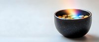 Cosmic black ceramic bowl with magical galaxy-like liquid reflection creates mystical atmosphere against minimalist light background. For spiritual concepts.