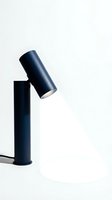 Minimalist navy blue adjustable desk lamp casting a bright beam of light on a white background, showcasing modern interior lighting design.
