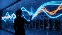 Business professional analyzing colorful data visualization waves on futuristic digital display screen for financial market trends and analytics.