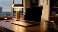 Laptop with blank screen on wooden desk by window at sunset, warm lighting from desk lamp, modern office workspace setup.