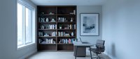Young professional male, Caucasian ethnicity, working at desk in modern home office with floor-to-ceiling black shelving unit, natural light from window, minimalist interior design for remote work and productivity.