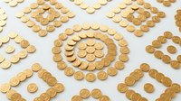 Golden coins arranged in geometric patterns and spirals on white surface, representing wealth, finance, savings, investment, and currency concepts for business and economic themes.