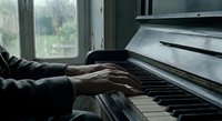 Elderly hands playing piano keys in cozy home setting with natural window light creating peaceful musical moment for relaxation and artistic expression.