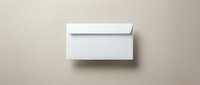 White envelope mockup on beige background with soft shadow for branding and stationery design projects.
