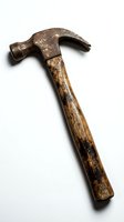 Vintage claw hammer with weathered metal head and worn wooden handle, showing age and patina from years of use in construction and carpentry work.
