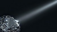 Sparkling diamond with brilliant cut facets reflecting light beam on dark background for luxury jewelry and precious stone concepts.