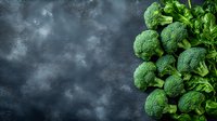 Fresh raw broccoli florets arranged on dark textured background with copy space. Green organic vegetables rich in vitamins and minerals for healthy eating.