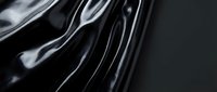 Abstract black liquid metal surface with flowing curves and reflective highlights creating dynamic waves and ripples for modern design backgrounds.