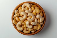 Roasted cashews in wooden bowl isolated on white background, ready for packaging design, food photography, and culinary projects.