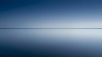 Serene ocean horizon with calm blue waters reflecting gradient sky from deep blue to light gray creating peaceful minimalist seascape for meditation and relaxation.