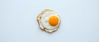Fried egg with golden yolk and crispy edges on white background, isolated and ready for food, cooking, and breakfast design projects.