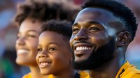 African American family enjoying outdoor sports event together, expressing joy and excitement with genuine smiles while watching game from stadium seats.
