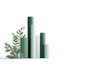 Minimalist green cylindrical columns of varying heights with decorative eucalyptus leaves against white background, creating modern architectural composition.