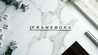 Wooden letter tiles spelling FRAMEWORK on white marble surface with eucalyptus leaves and office supplies for business planning and strategy concepts.