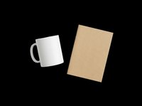 White ceramic mug and kraft notebook set isolated on transparent background, ready for branding mockups, stationery clipart, print on demand, and t-shirt design use.