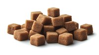 Brown sugar cubes scattered in artistic arrangement on white background, showing crystalline texture and rich caramel color, isolated for commercial food photography.