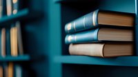 Stack of hardcover books on turquoise wooden shelf in library or study room with soft focus background creating cozy reading atmosphere.