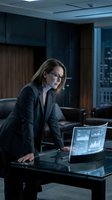 Professional woman in business attire analyzing financial data on holographic display in modern office environment. Suitable for corporate, technology, and finance concepts.