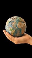 Hand holding textured globe made from recycled paper and cardboard, isolated on transparent background. Ready for environmental, sustainability, education, and business design projects including t-shirts, posters, and print materials.