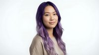 Young Asian woman with purple ombre hair wearing beige blazer smiling confidently against white background for professional headshot and business portrait.