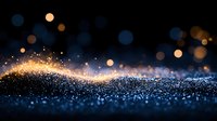 Magical glowing wave of golden sparkles and blue bokeh lights on dark background creates dreamy atmospheric effect. Festive holiday abstract design element.