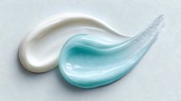 Creamy white and turquoise cosmetic product swatches on light background, showcasing skincare texture for beauty advertising and product photography.