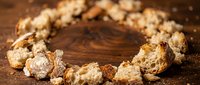 Scattered cereal pieces arranged in circular pattern on wooden surface with crumbs, suitable for food photography, breakfast advertising, and nutritional content.